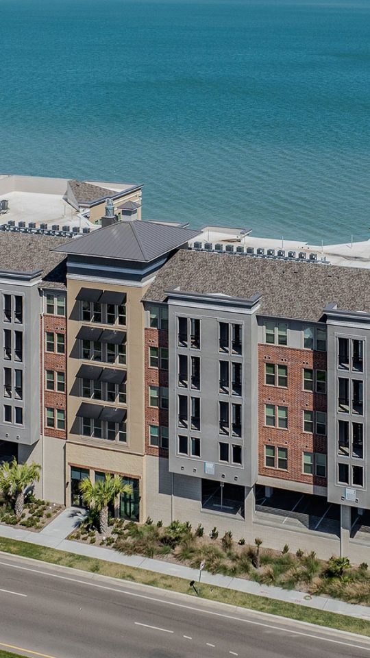 an aerial view of a large apartment complex near the ocean at The  Alexa