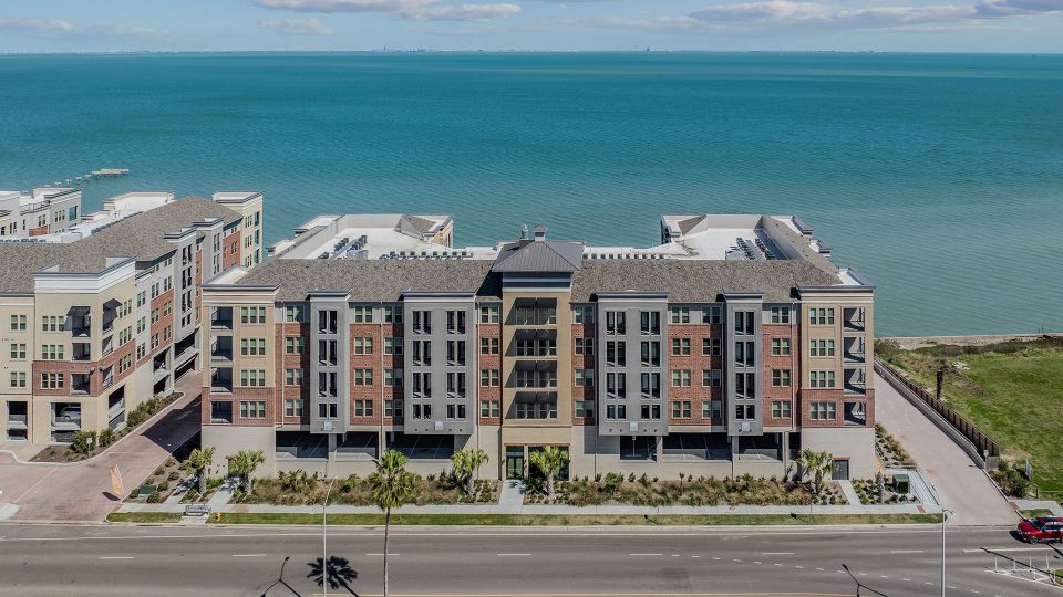 an aerial view of a condo building with the ocean in the background at The  Alexa