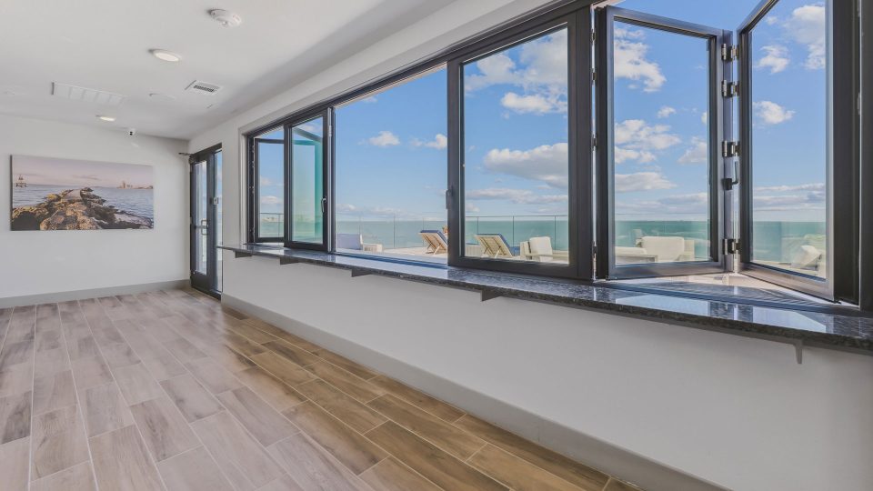a large room with windows overlooking the ocean at The  Alexa