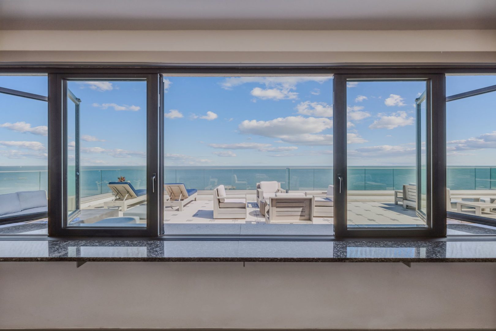 a large window overlooking the ocean and the beach at The  Alexa